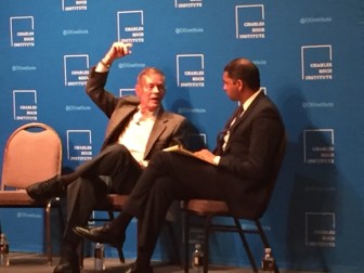Race car legend and New Mexico icon Bobby Unser, left, tells the Charles Koch Institute’s Vikrant Reddy the story of his tangle with the federal government in 1996 during an event in Albuquerque last week.