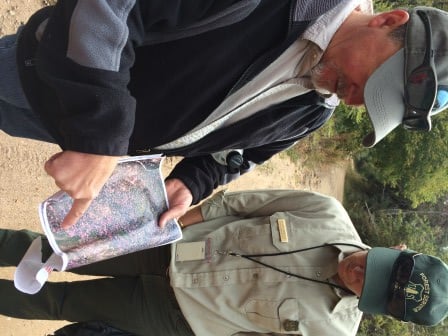 Shawn Martin, Silviculturist for Cibola National Forest's Sandia District, and Meckenzie Helmandollar, former acting public affairs officer for the Cibola National Forest look at an areal image of conifer stands. 